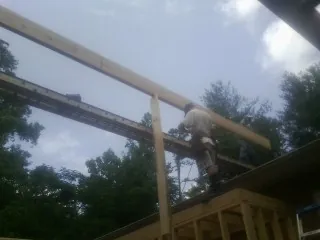 Carpenter setting a ridge beam over a new addition frame — Ice Dam Removal by Roofing Brothers in South Walpole