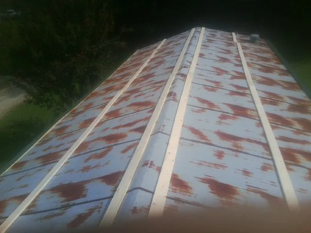 Rusted metal roof panels with new wood purlins before replacement — Storm Damage Roof Repair in South Walpole by Roofing Brothers