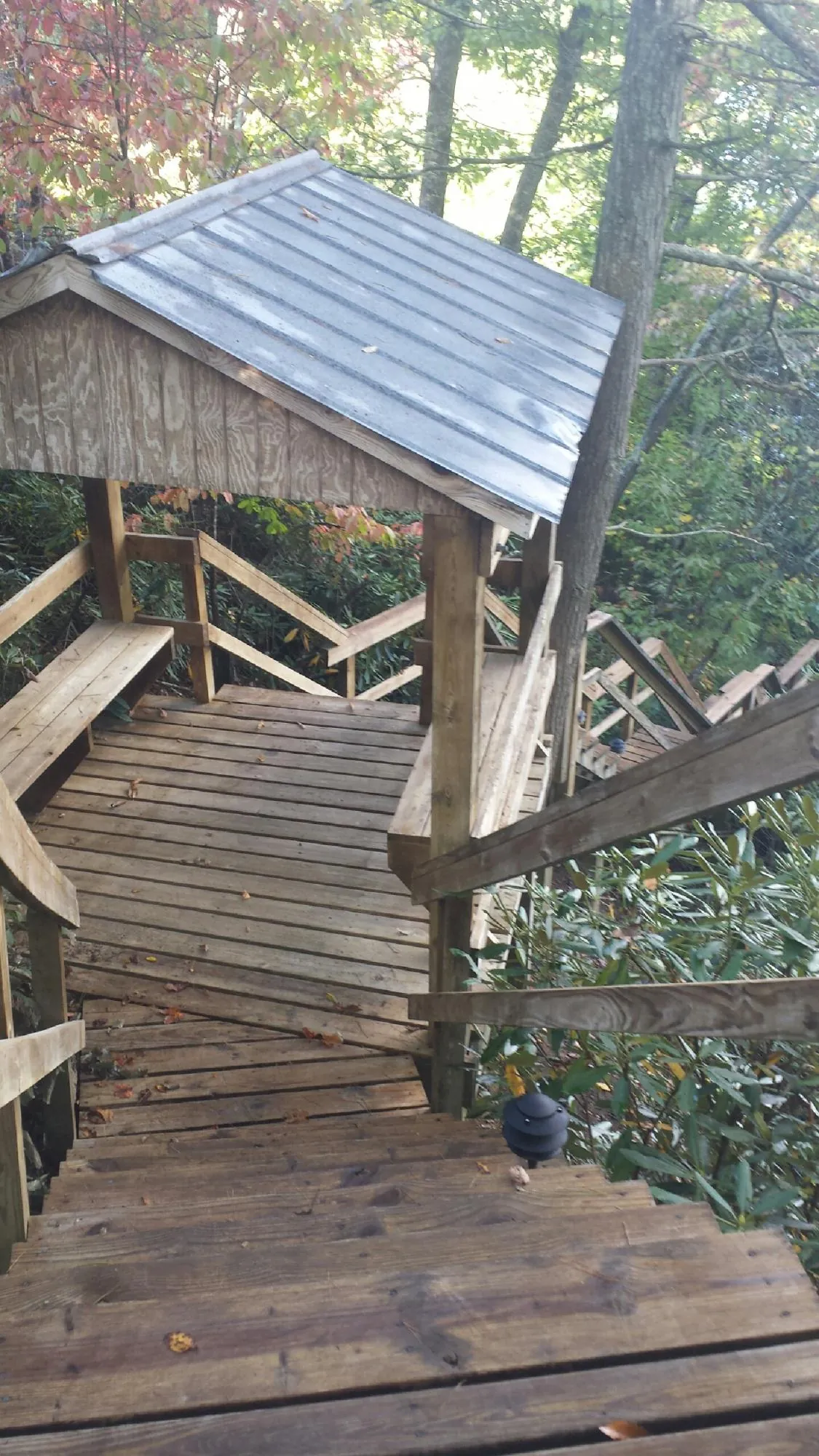 Metal roofed shelter over wooden steps on a wooded walkway — Skylight Repair & Installation work by our crew in South Walpole