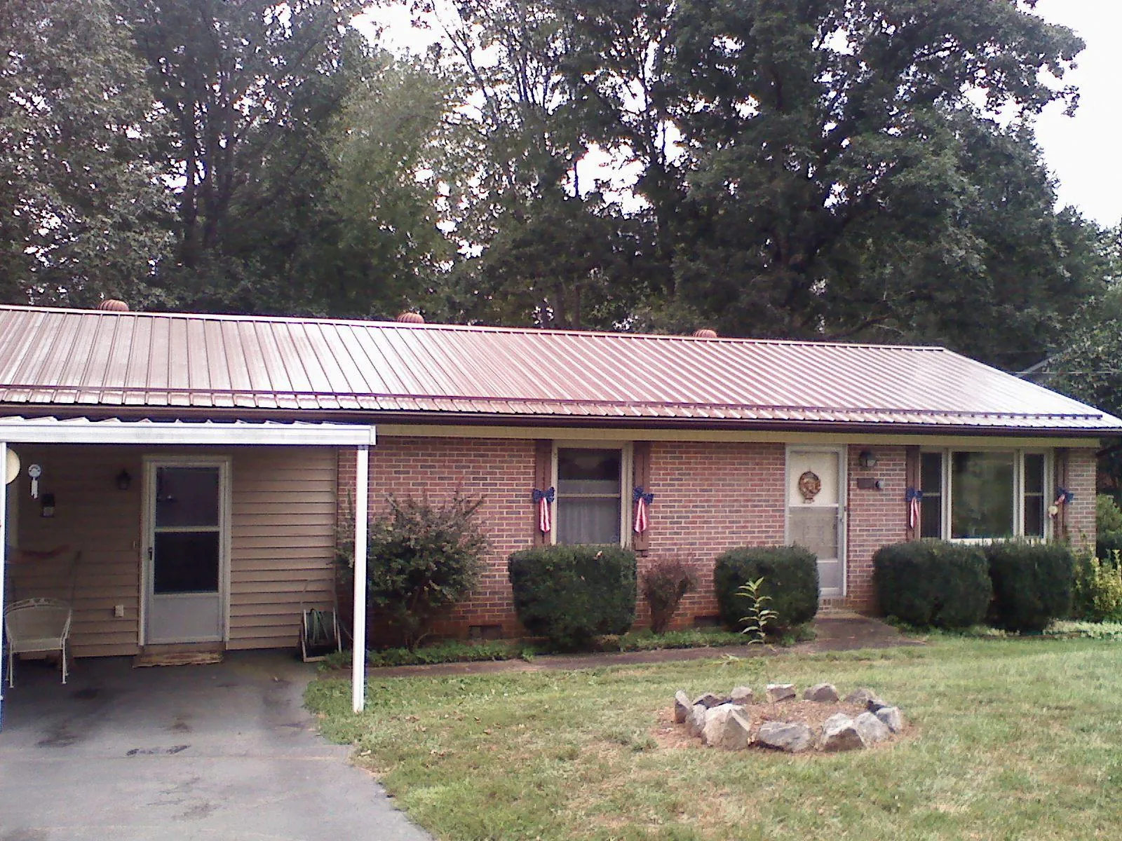 Bronze metal roof and carport on a brick ranch home — Roof Repair work by our crew in South Walpole